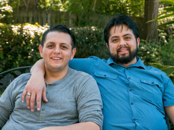 Two people sitting on bench smiling